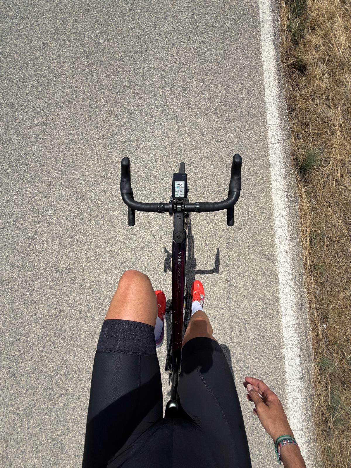 Vista de una bicicleta y las piernas de Miguel mientras pedalea por una carretera